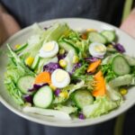 A person holding a salad bowl