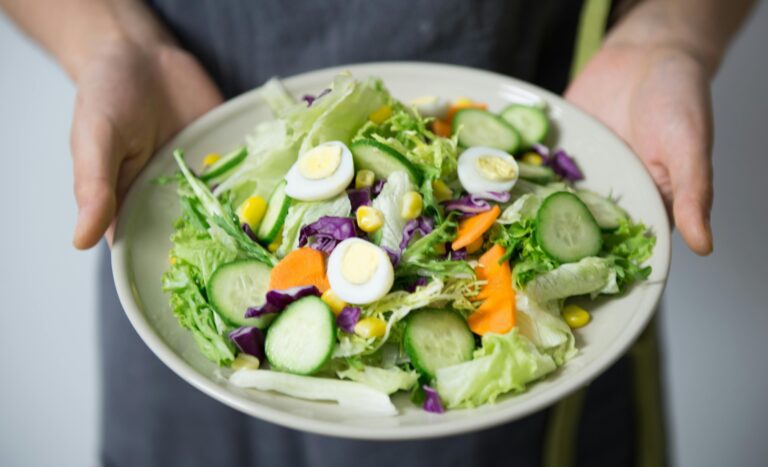 A person holding a salad bowl